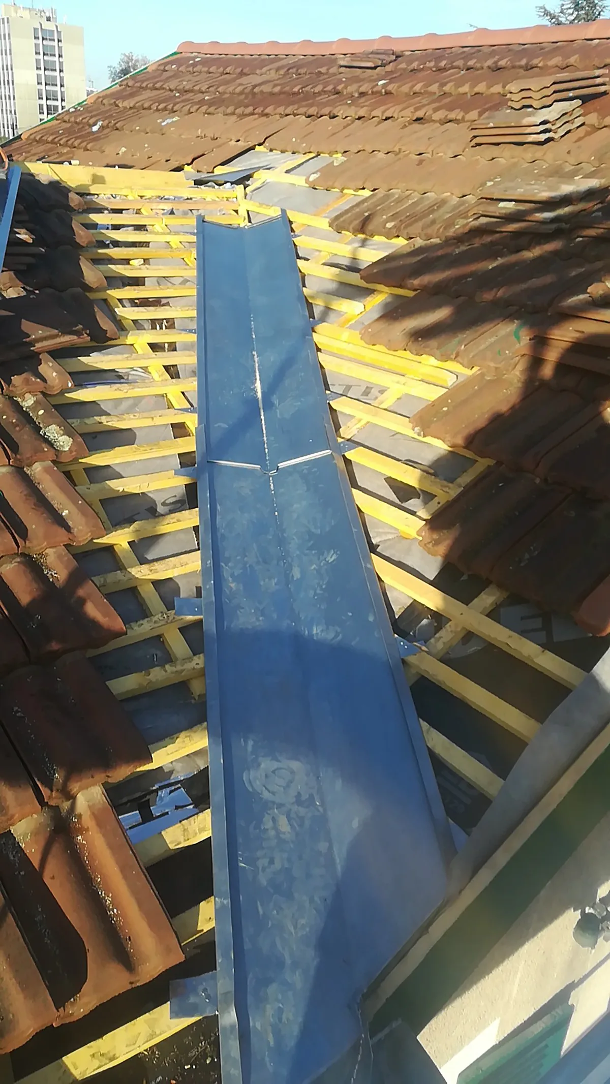 Façonnage et pose d'une noue en zinc entre deux pans de toiture en tuiles