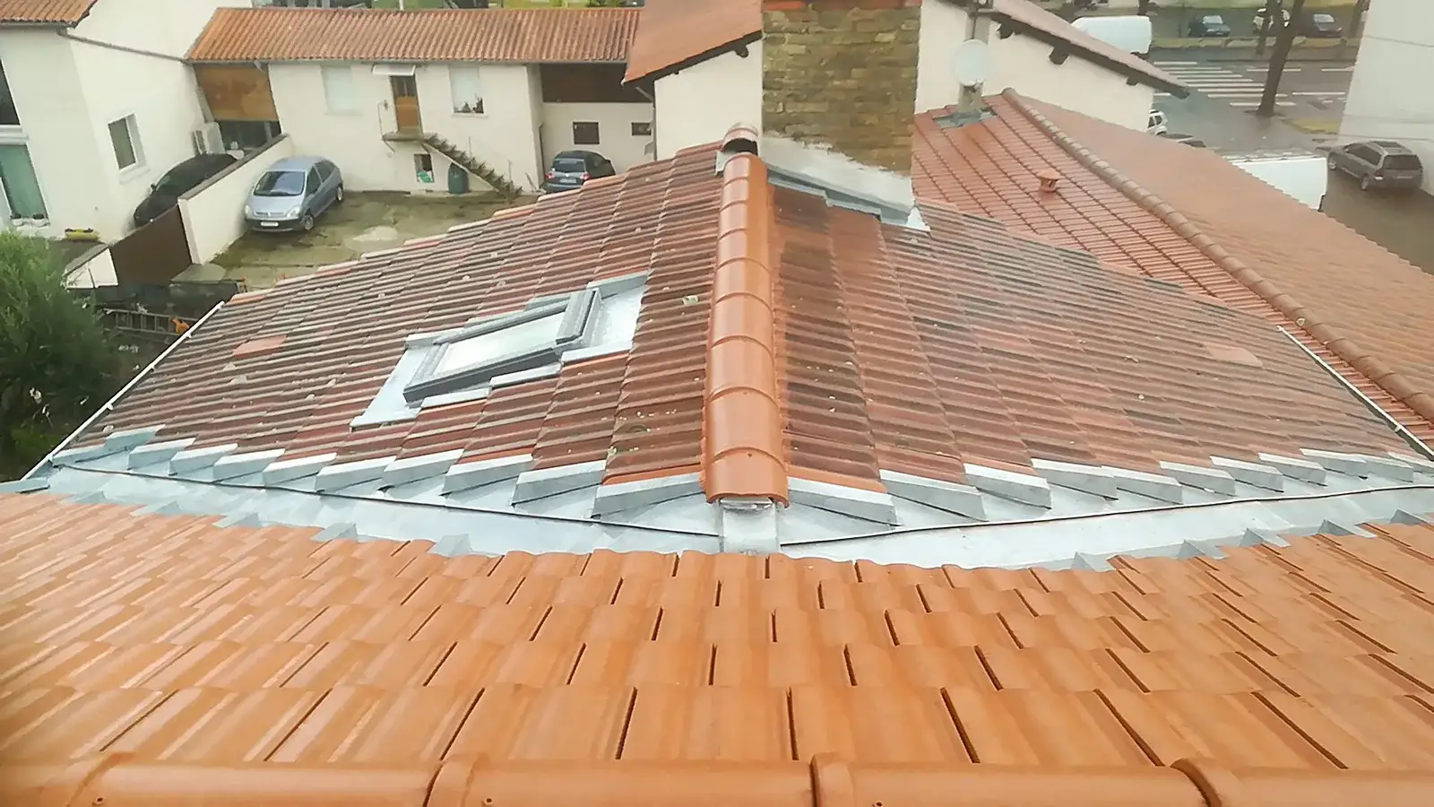 Solin de cheminée en zinc et fenêtre de toit sur une toiture en tuiles